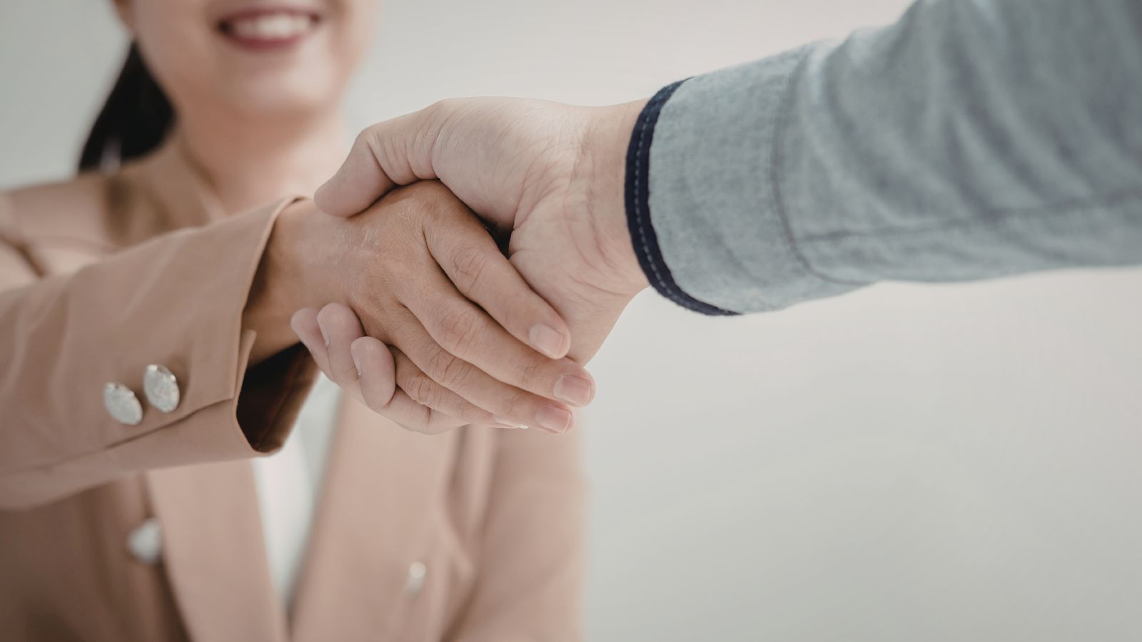 Two professional people shaking hands in symbolism of a partnership.